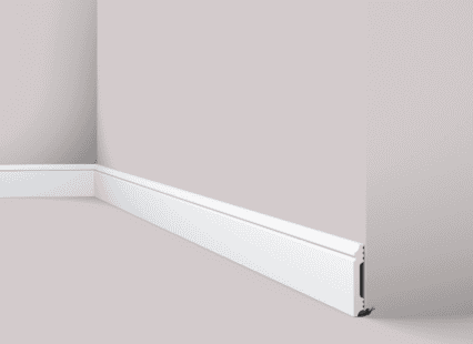 Coving and skirting board installed at the junction of the wall and floor.