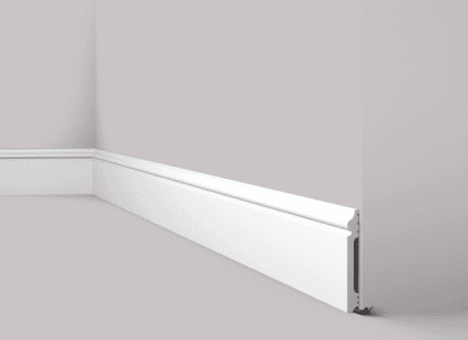 Coving and skirting board installed along the wall corner in a modern interior.