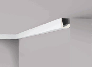 Close-up of white decorative coving installed at ceiling corner.