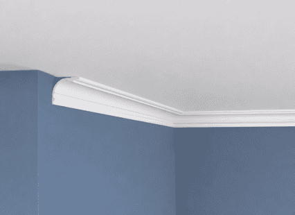 Coving decorative moulding installed at the junction of a white ceiling and blue wall.
