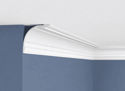 Coving with decorative white plaster moulding installed at the junction of the ceiling and wall.