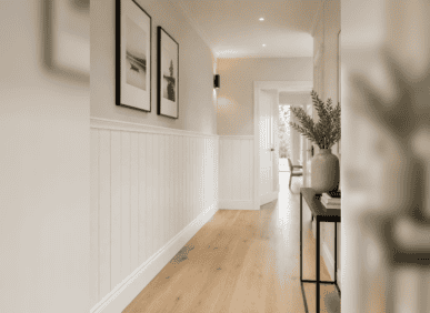 UK Home Interiors wall panelling in a hallway with artwork and decor.